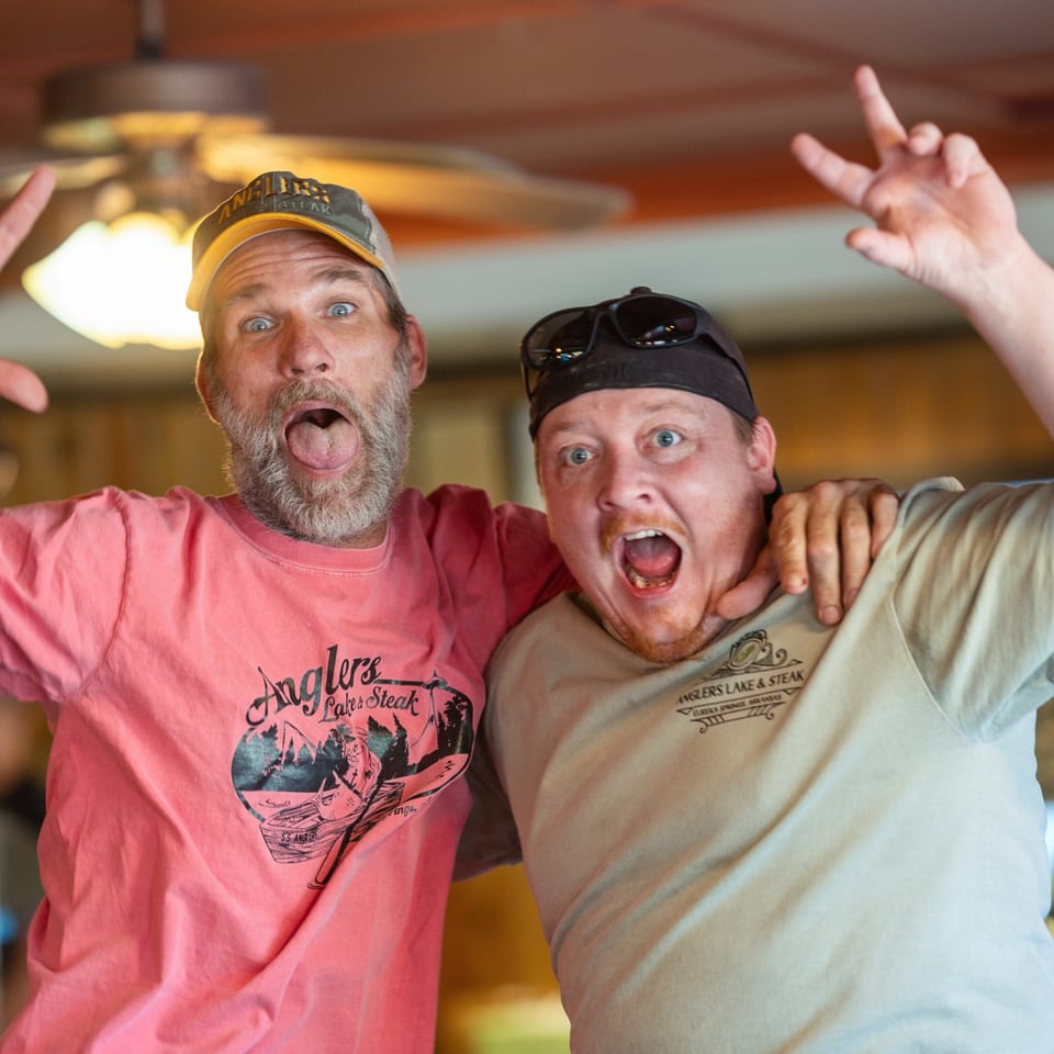 Two Angler's team members posing together in restaurant shirts.