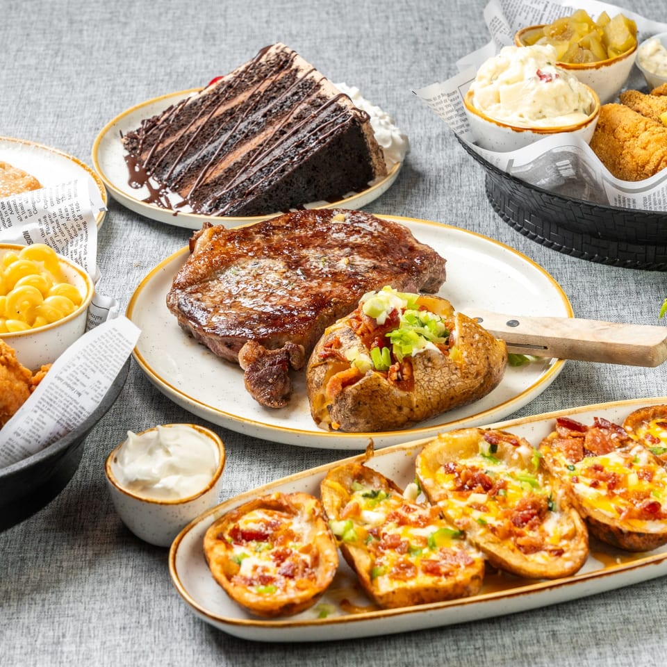 Angler's food spread with steak, fish, potato skins and desserts.